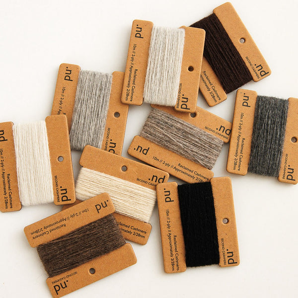 Collection of fabric swatches with brown cards on a white background
