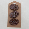 Three brown buttons on a cardboard backing against a white background