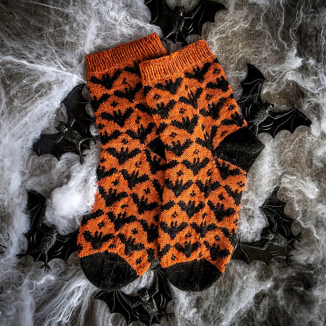 Orange and black patterned socks on a spider web background