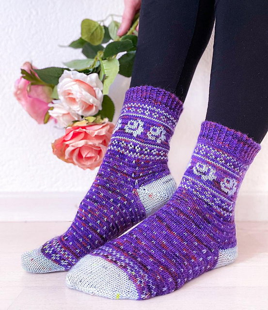 Purple patterned socks worn by a person with flowers in the background