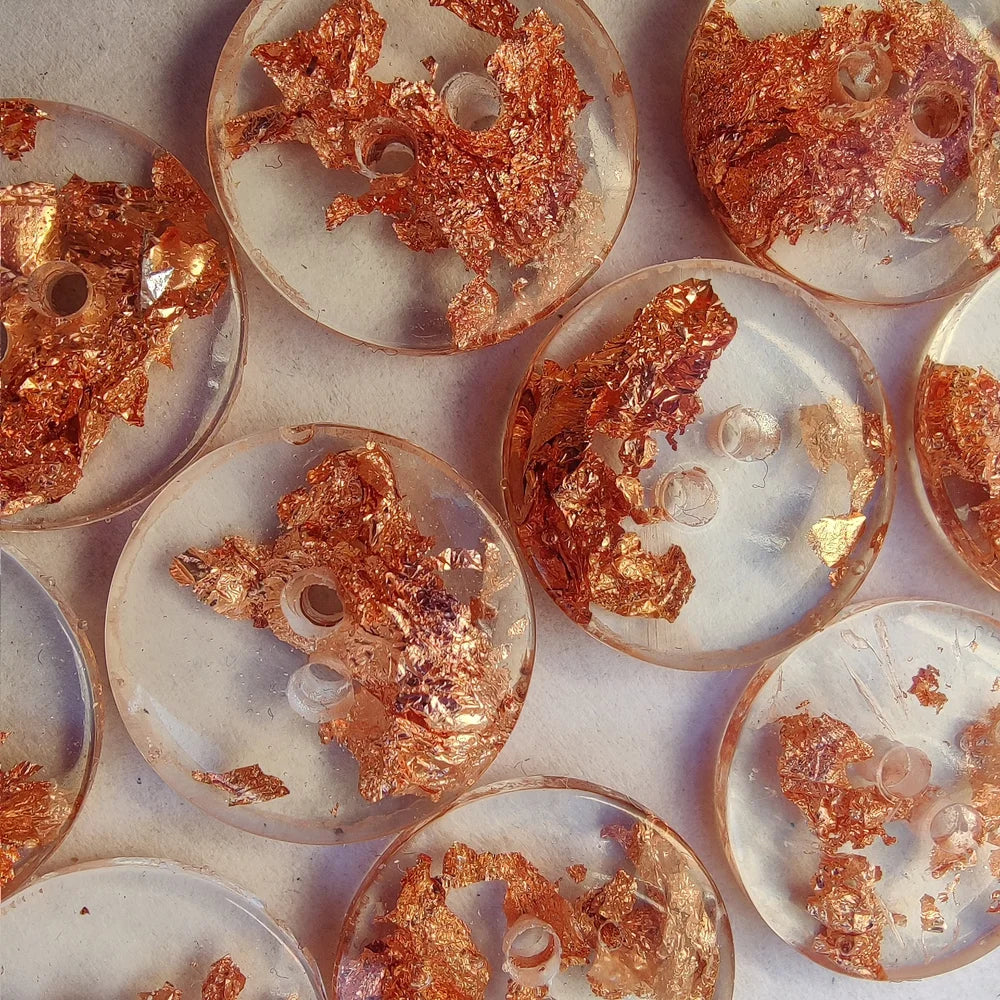 Closeup of clear buttons with copper flecks