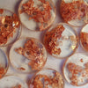 Closeup of clear buttons with copper flecks