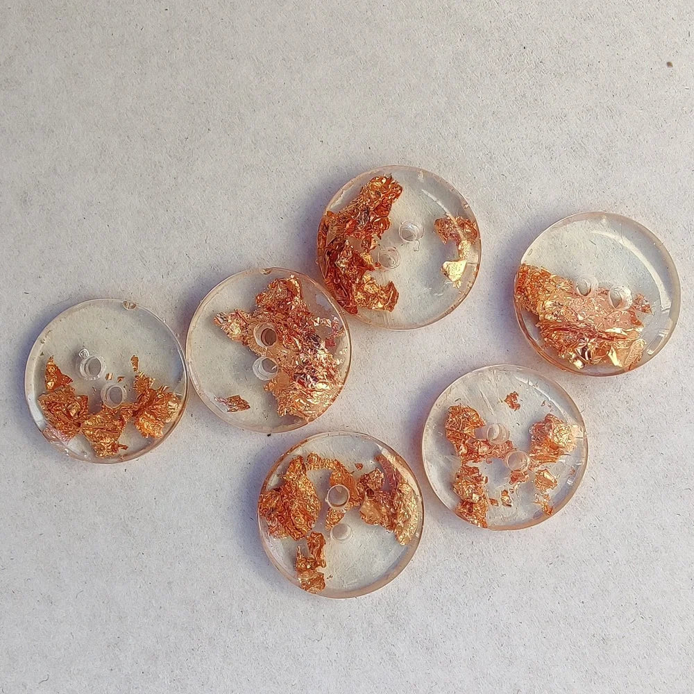 closeup of clear buttons with a copper flake