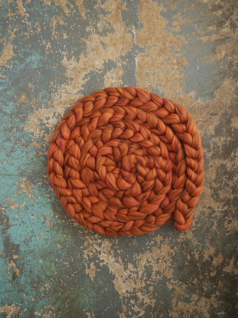 Coiled orange rope on a textured surface