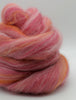 Pink and orange yarn skein on a white background