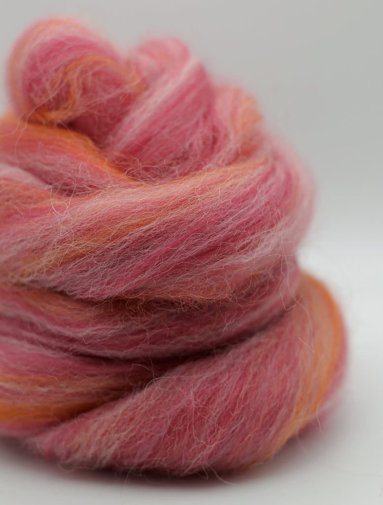 Pink and orange yarn skein on a white background