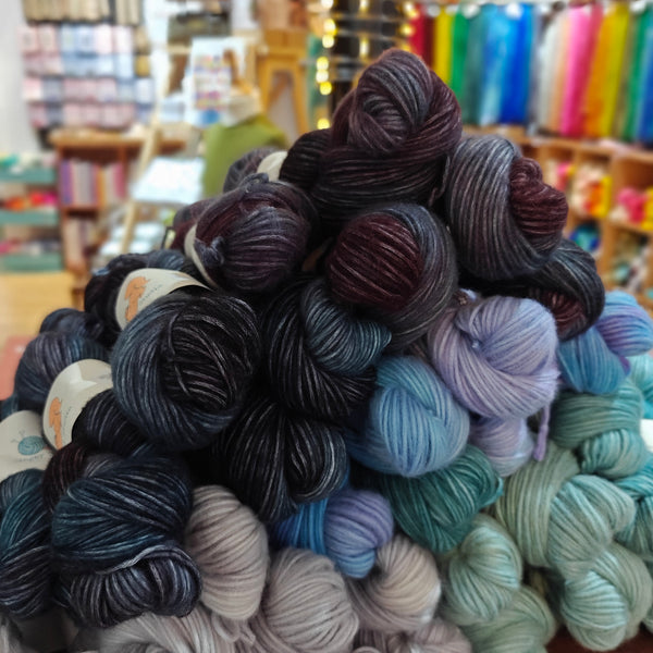 Collection of yarn balls in various colors with a blurred store background