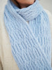 Close-up of a light blue knitted scarf being worn.