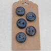 Set of blue buttons on a cardboard backing against a white background