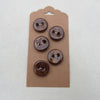 Five brown buttons on a cardboard backing against a white background