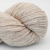 Ball of yarn with a speckled pattern on a light background