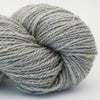 Close-up of a skein of gray yarn with speckles on a light background