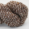 Close-up of a skein of brown and white yarn on a light gray background