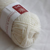 Ball of white yarn with a label on a white background