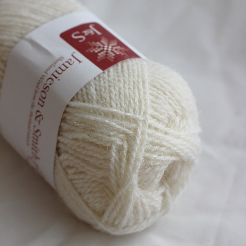Ball of white yarn with a label on a white background