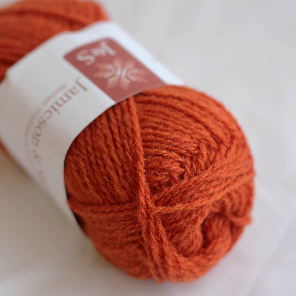 Orange yarn ball with a label on a white background