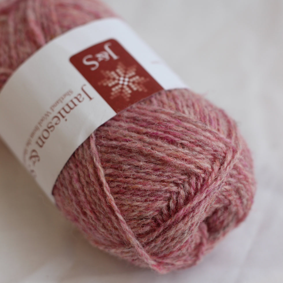 Ball of pink yarn with a label on a white background