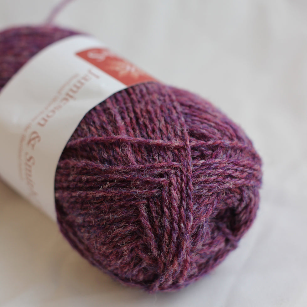 Ball of purple yarn with a label on a light background