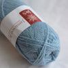 Ball of light blue yarn with a label on a white background