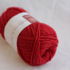 Red skein of yarn with a label on a white background