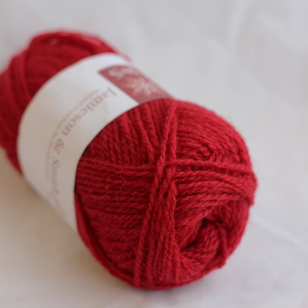 Red skein of yarn with a label on a white background