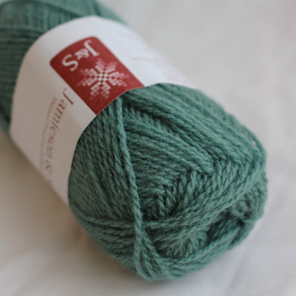 Green skein of yarn with a label on a white background