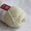 Ball of cream-colored yarn with a label on a white background