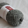 Ball of gray yarn with a label on a white background