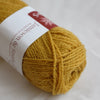 Ball of yellow yarn with a label on a white background