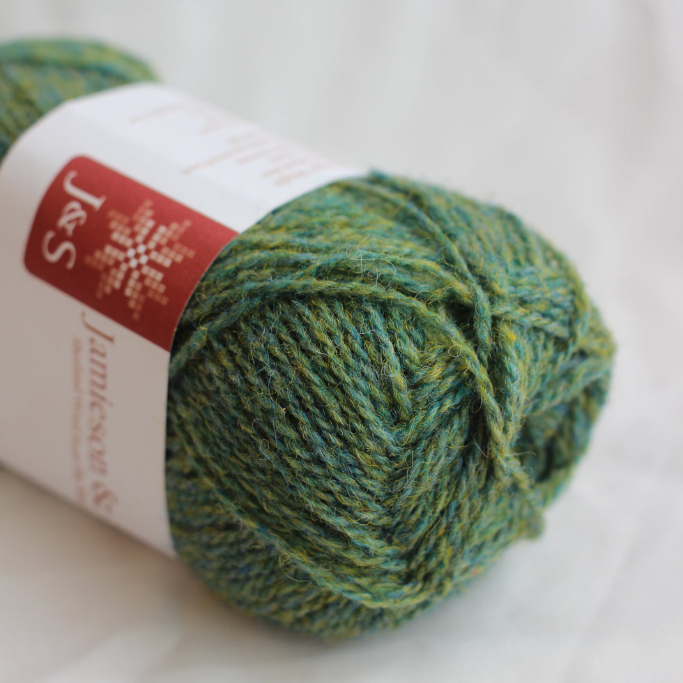 Green yarn ball with a label on a white background