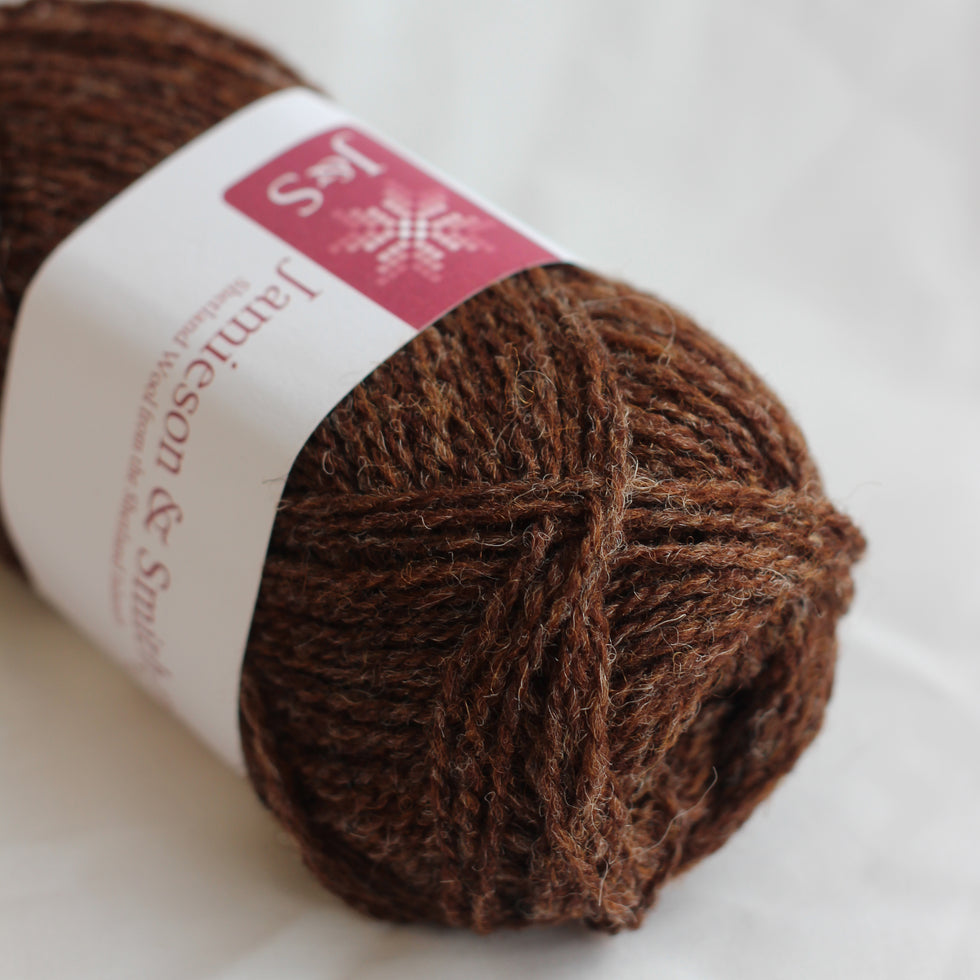 Brown yarn ball with a label on a white background