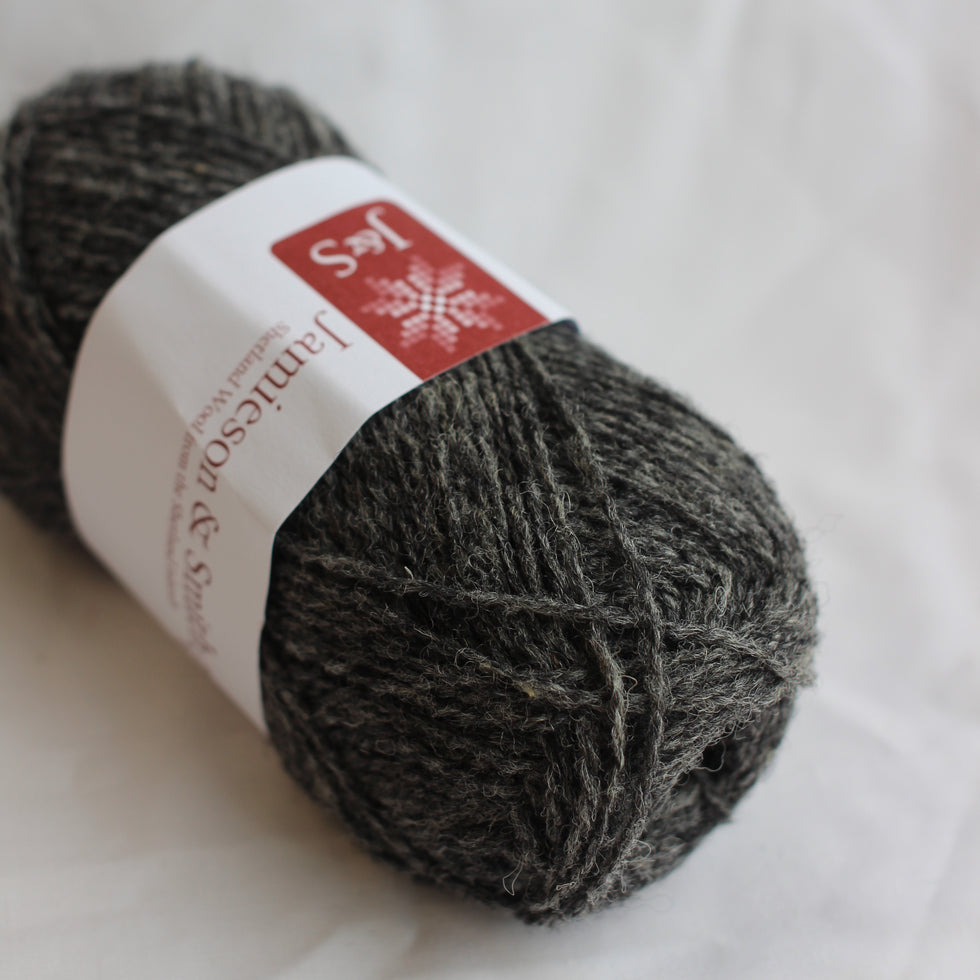 Ball of gray yarn with a label on a white background