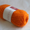 Orange yarn ball with a label on a light background