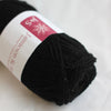 Ball of black yarn with a label on a white background