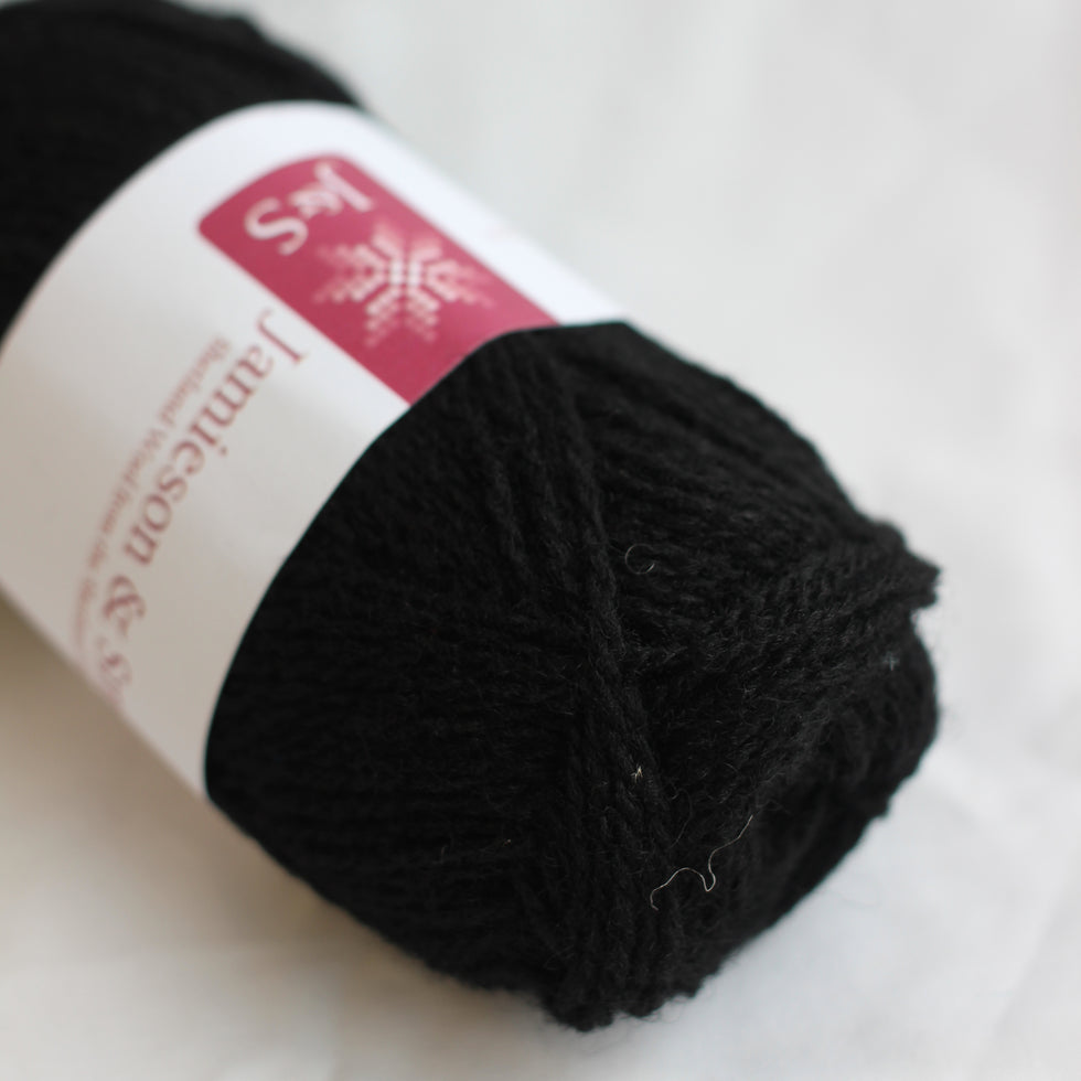 Ball of black yarn with a label on a white background