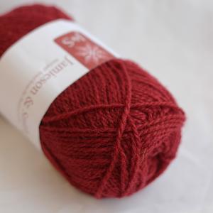 Red skein of yarn with a label on a white background