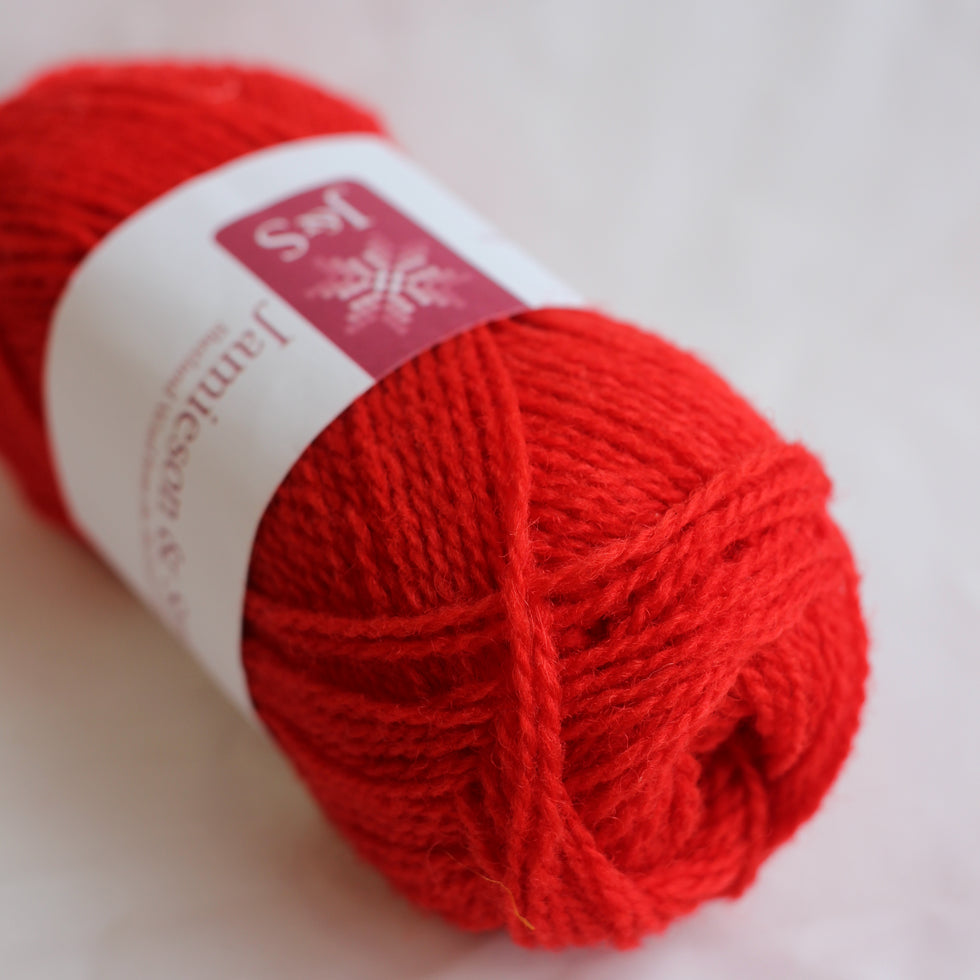 Red yarn ball with a label on a light background