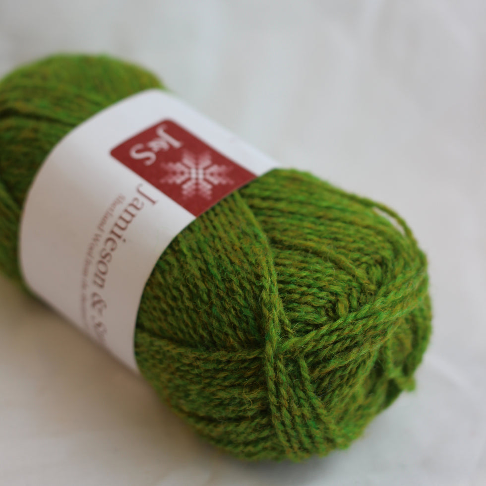 Green skein of yarn with a label on a white background