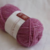 Ball of pink yarn with a label on a light background