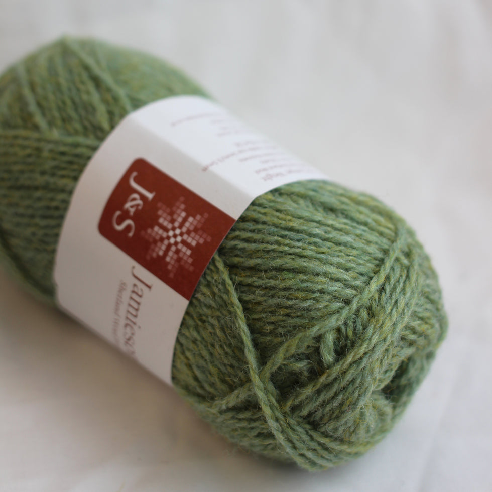 Green skein of yarn with a label on a white background