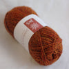 Ball of brown yarn with a label on a white background