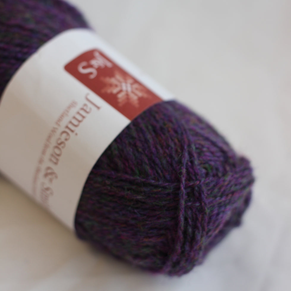 Ball of purple yarn with a label on a light background