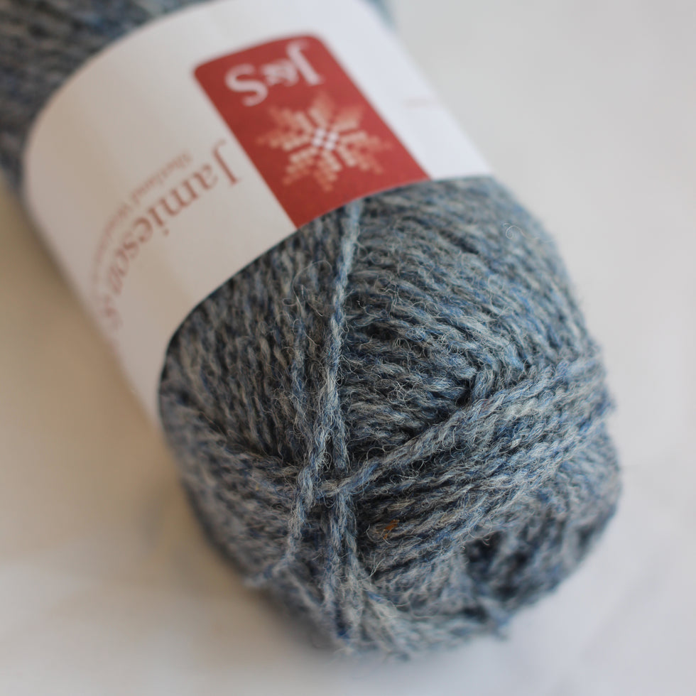 Ball of gray yarn with a label on a light background