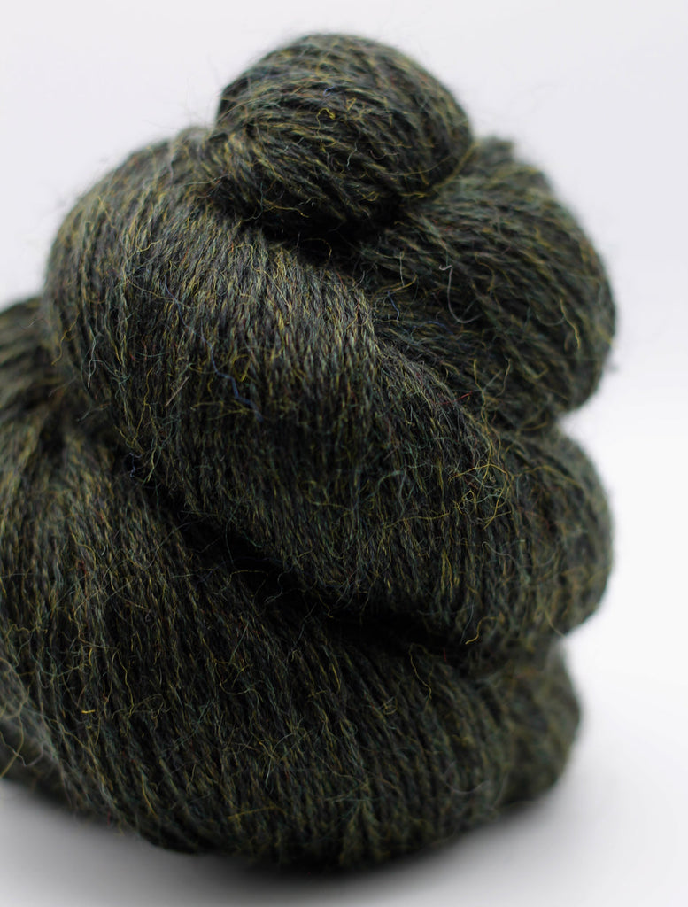 Knotted skein of dark green yarn on a white background