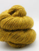 Mustard yellow skein of yarn on a white background