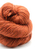 Close-up of a skein of orange yarn on a white background