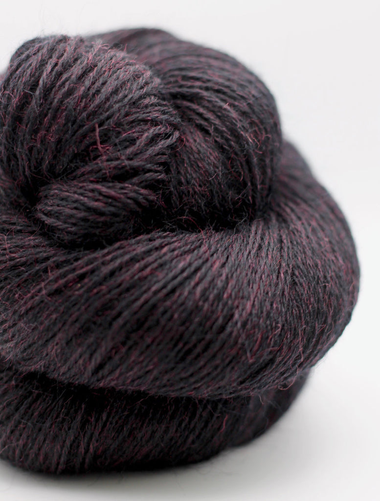 Dark purple skein of yarn on a white background