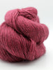 A close-up of a skein of textured yarn in a deep berry pink color, set against a clean white background.