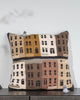 Crocheted pillow with building pattern on a wooden surface