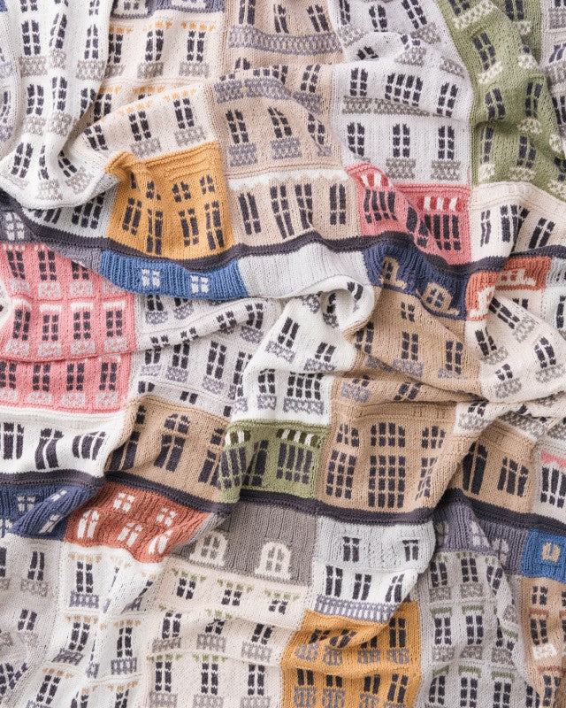 Textile with a pattern of small houses in various colors.